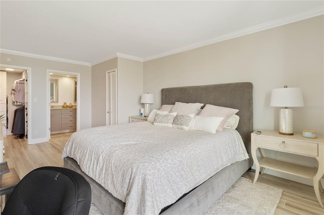 bedroom with ensuite bathroom, a closet, crown molding, and light hardwood / wood-style flooring