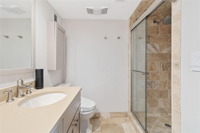 bathroom with toilet, vanity, and an enclosed shower