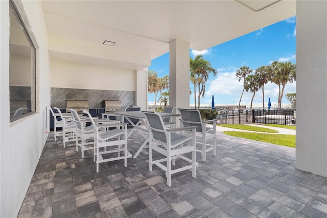 view of patio / terrace featuring a grill, an outdoor kitchen, and a water view