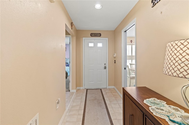 entrance foyer featuring light tile patterned floors, visible vents, and baseboards