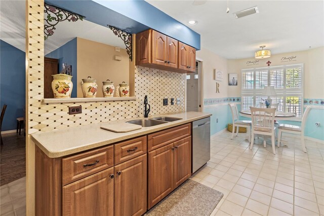 kitchen with sink, light tile patterned floors, stainless steel dishwasher, and decorative backsplash