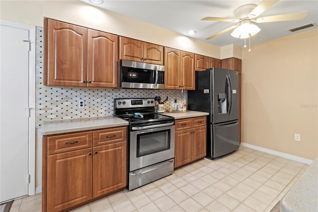 kitchen with light tile patterned flooring, ceiling fan, stainless steel appliances, and backsplash