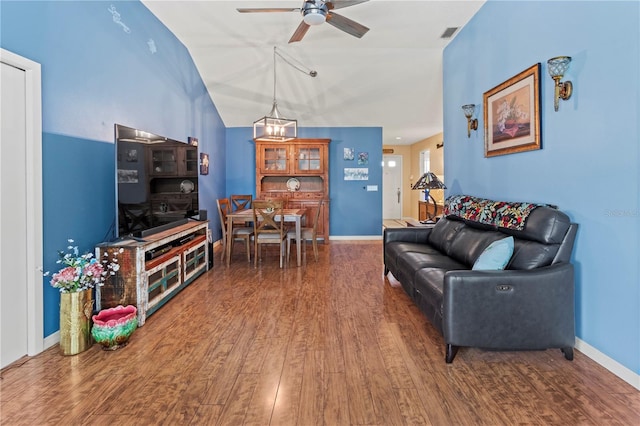 living room with ceiling fan, lofted ceiling, and dark hardwood / wood-style flooring