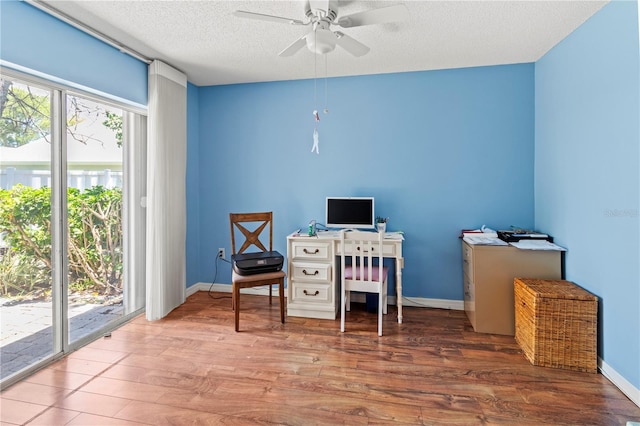 office featuring plenty of natural light, a textured ceiling, a ceiling fan, and wood finished floors