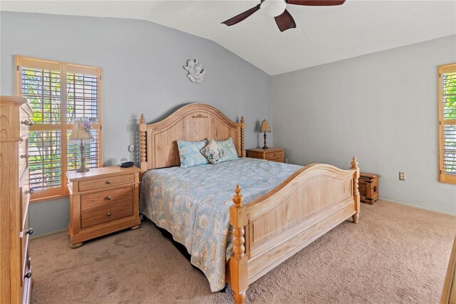 bedroom with light carpet, multiple windows, vaulted ceiling, and a ceiling fan