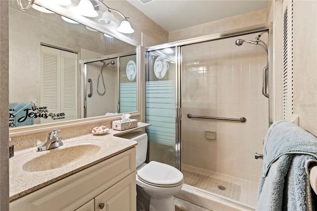 full bathroom with a closet, a stall shower, vanity, and toilet