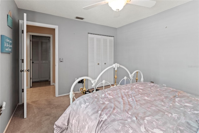 carpeted bedroom featuring ceiling fan and a closet