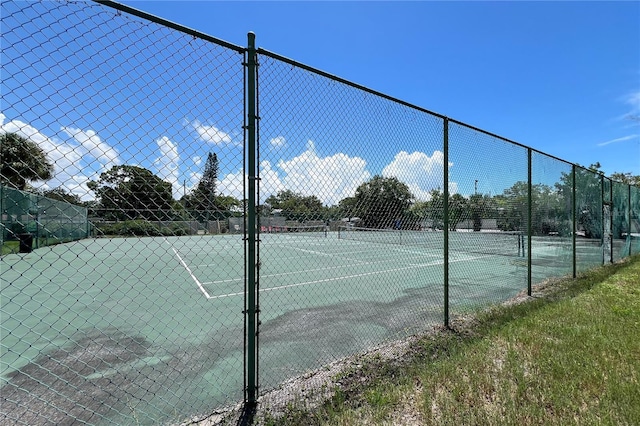 view of tennis court featuring fence