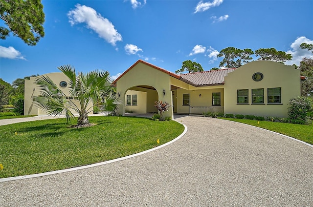 mediterranean / spanish-style house with a front lawn