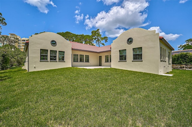 back of property with a patio area and a lawn