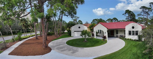 mediterranean / spanish home featuring a front lawn and a garage