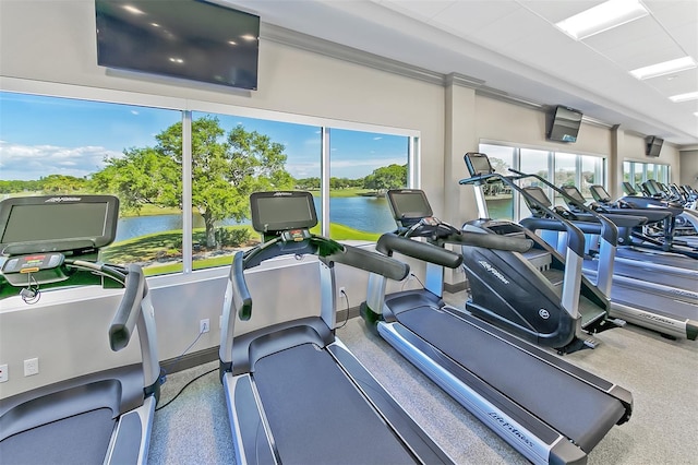 exercise room featuring a water view and a wealth of natural light