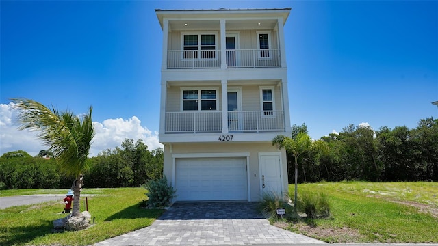 raised beach house featuring a balcony and a front yard