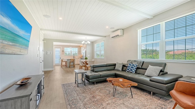 living room with a wealth of natural light, beamed ceiling, a chandelier, and light hardwood / wood-style floors