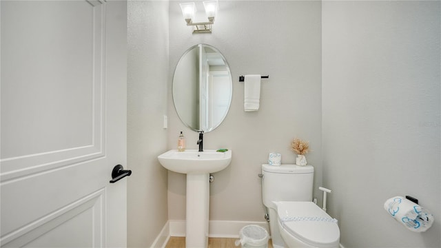 bathroom featuring wood-type flooring and toilet