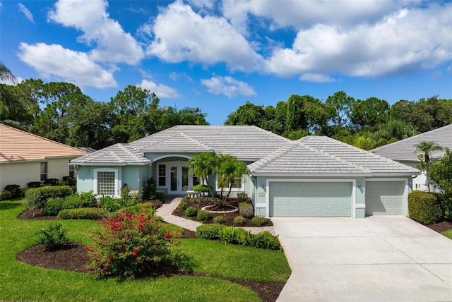5249 Far Oak Cir, Sarasota, FL 34238 - ranch-style home featuring french doors, an attached garage, driveway, a tile roof, and stucco siding