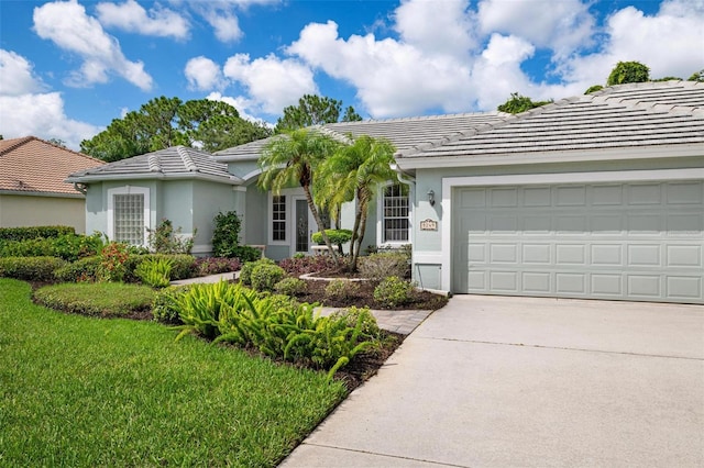 ranch-style home featuring a garage and a front lawn