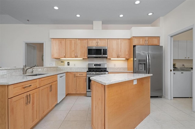 kitchen featuring stainless steel appliances, sink, light stone counters, light tile patterned floors, and a kitchen island