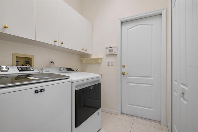 washroom featuring cabinets, washer and clothes dryer, and light tile patterned floors