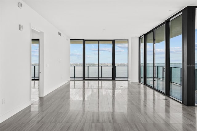 empty room with expansive windows and a water view