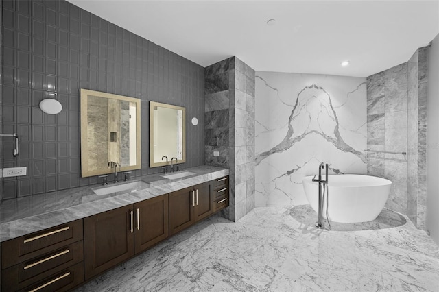 bathroom with vanity, a bath, and tile walls