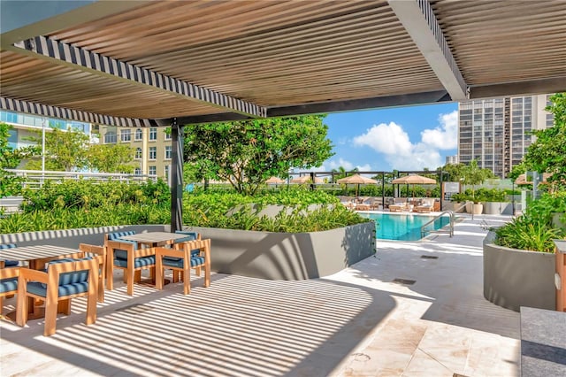 view of patio / terrace featuring a community pool and a pergola