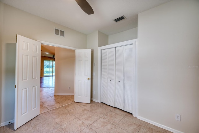 unfurnished bedroom featuring ceiling fan, a closet, and light tile patterned floors