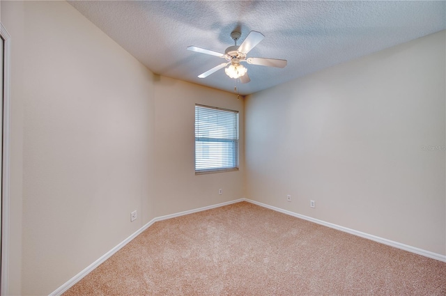 carpeted spare room featuring a textured ceiling and ceiling fan