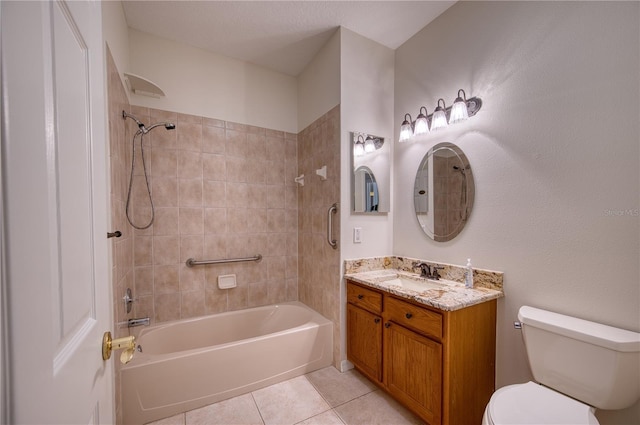 full bathroom featuring tiled shower / bath, tile patterned floors, toilet, and vanity