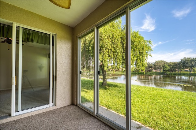 doorway to outside featuring a water view, lofted ceiling, carpet floors, and a wealth of natural light