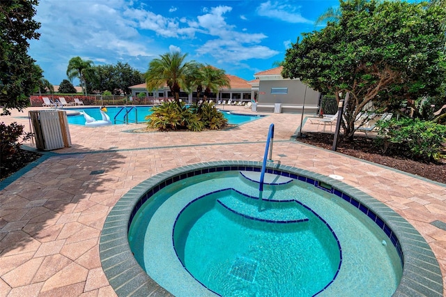 view of pool with a hot tub