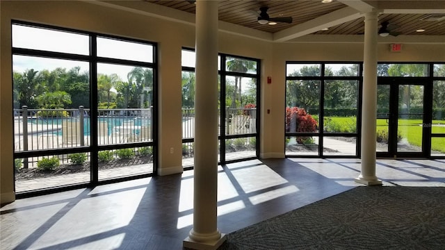 doorway to outside featuring ceiling fan, wooden ceiling, and ornate columns