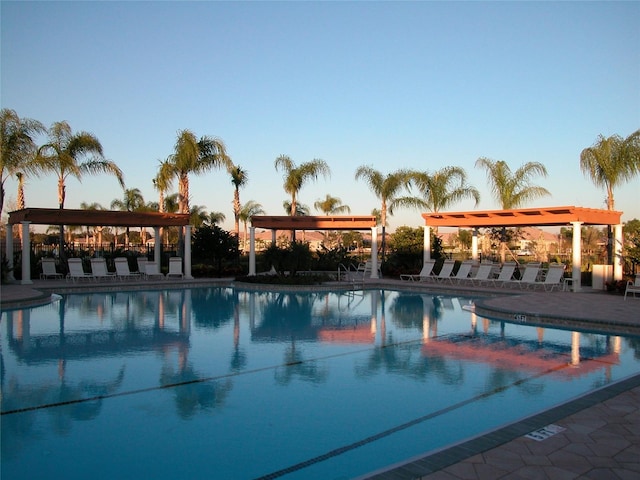 pool at dusk featuring a gazebo and a patio