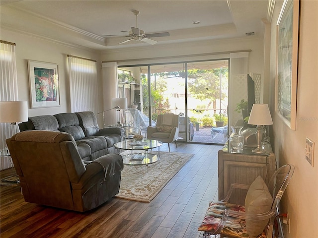 living area with ornamental molding, a tray ceiling, and a wealth of natural light