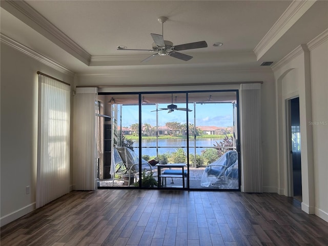 spare room featuring a water view, crown molding, a raised ceiling, and wood finished floors