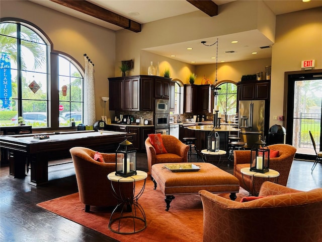 living area featuring dark wood-style floors, visible vents, beam ceiling, and a healthy amount of sunlight