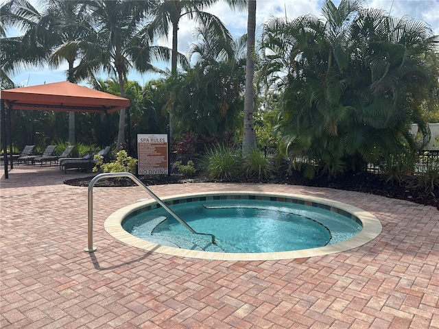 view of pool featuring a community hot tub, a gazebo, and a patio area