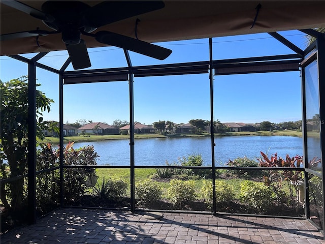 unfurnished sunroom with a water view, a healthy amount of sunlight, and a ceiling fan