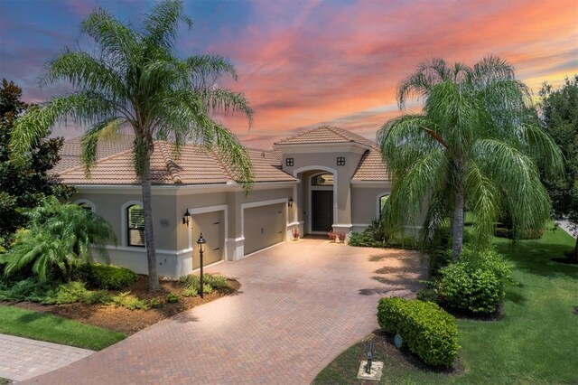 mediterranean / spanish-style house featuring a yard and a garage