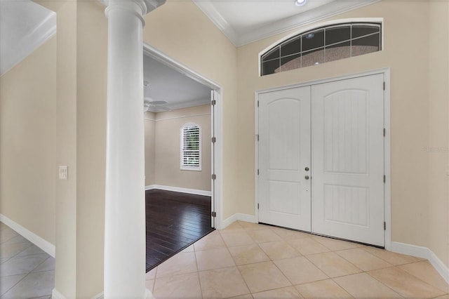 entrance foyer featuring ceiling fan, ornamental molding, decorative columns, and light tile patterned floors