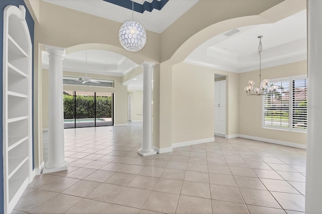 tiled spare room with decorative columns, ornamental molding, ceiling fan with notable chandelier, and a tray ceiling