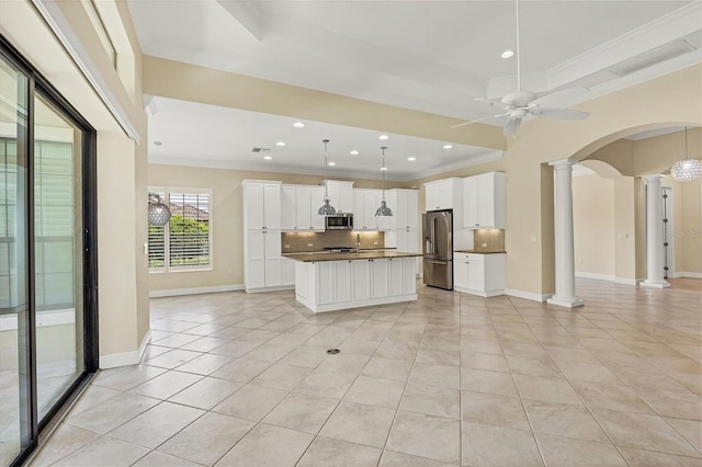 kitchen with white cabinetry, ornamental molding, appliances with stainless steel finishes, and decorative columns