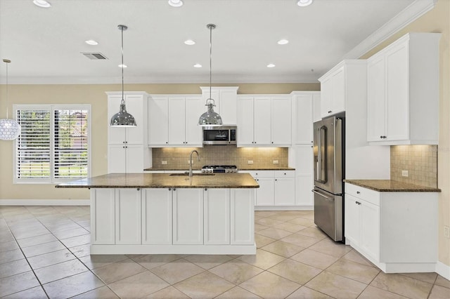 kitchen featuring stainless steel appliances, an island with sink, and decorative light fixtures