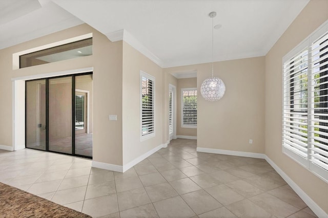 tiled spare room featuring a notable chandelier