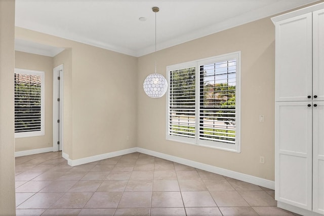 tiled empty room featuring crown molding