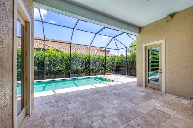 view of swimming pool featuring a patio area and glass enclosure