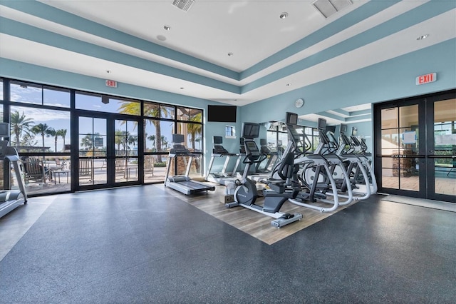 gym with french doors and a high ceiling