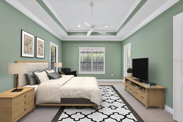 carpeted bedroom with ceiling fan, ornamental molding, and a tray ceiling