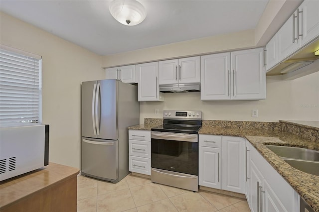 kitchen featuring dark stone counters, white cabinetry, stainless steel appliances, sink, and light tile patterned floors