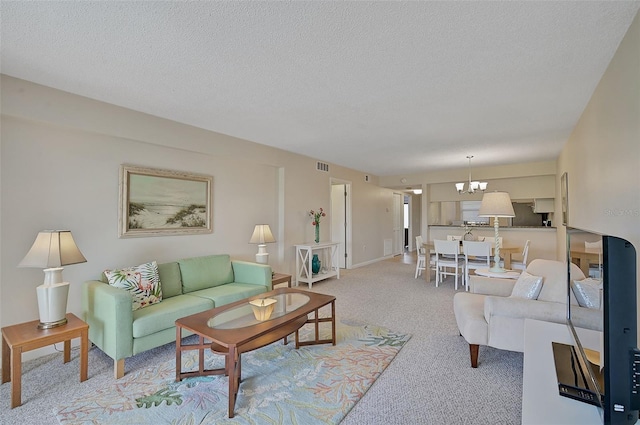 living room with an inviting chandelier, light carpet, and a textured ceiling